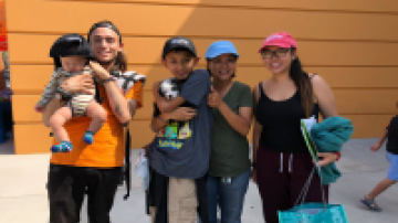 Young adults holding children pose for a photo
