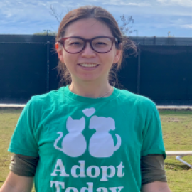 Mandy, OC Animal Care volunteer of the month wearing a green shirt that reads "Adopt Today"