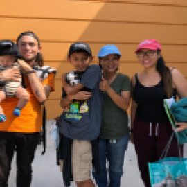 Young adults holding children pose for a photo