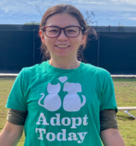 Mandy, OC Animal Care volunteer of the month wearing a green shirt that reads "Adopt Today"