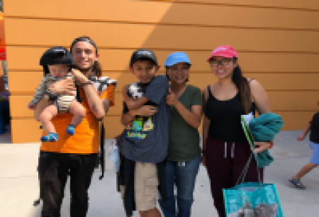 Young adults holding children pose for a photo